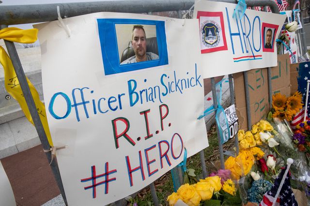 Signs and flowers in tribute to Brian Sicknick in Washington DC